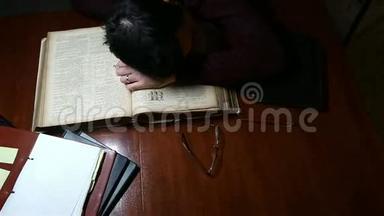 在旧圣经上睡觉的人